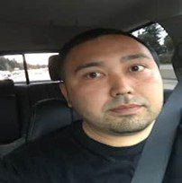 Man with a neutral expression sitting in a car.