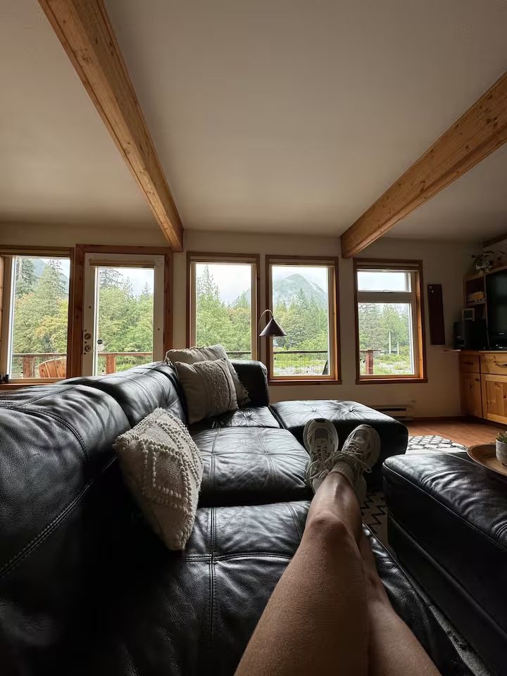 Relaxing on a couch with a scenic window view of nature.