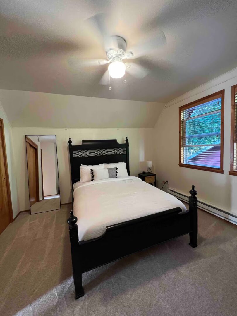 Cozy bedroom with a black wooden bed and neutral decor.