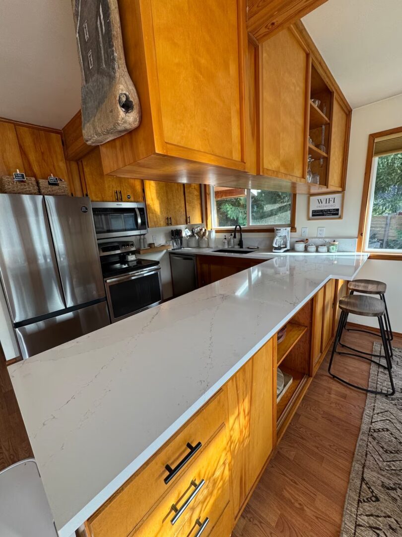 Modern kitchen with wooden cabinets and a large white countertop island.