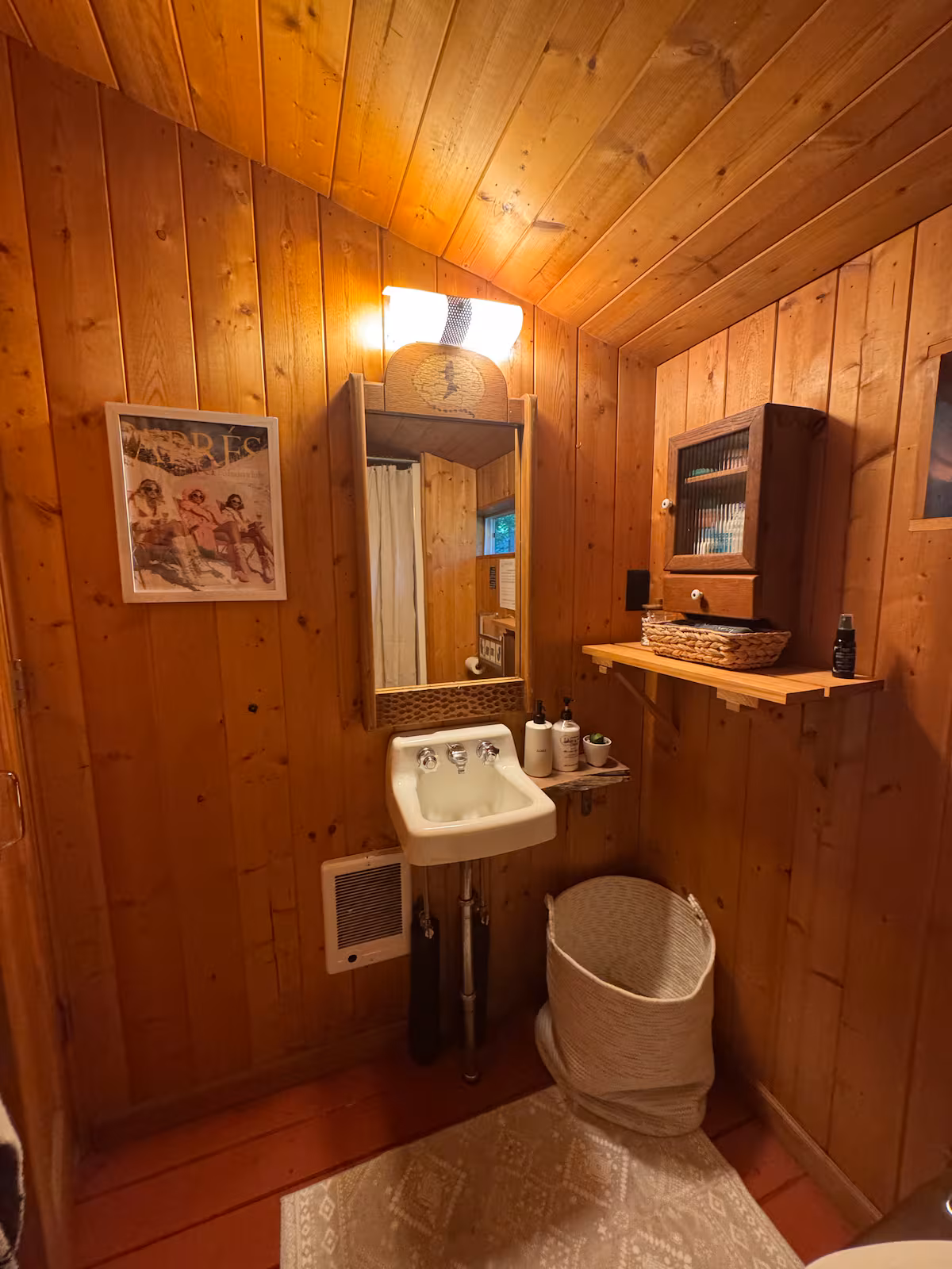 Cozy wooden bathroom with vintage sink and mirror.