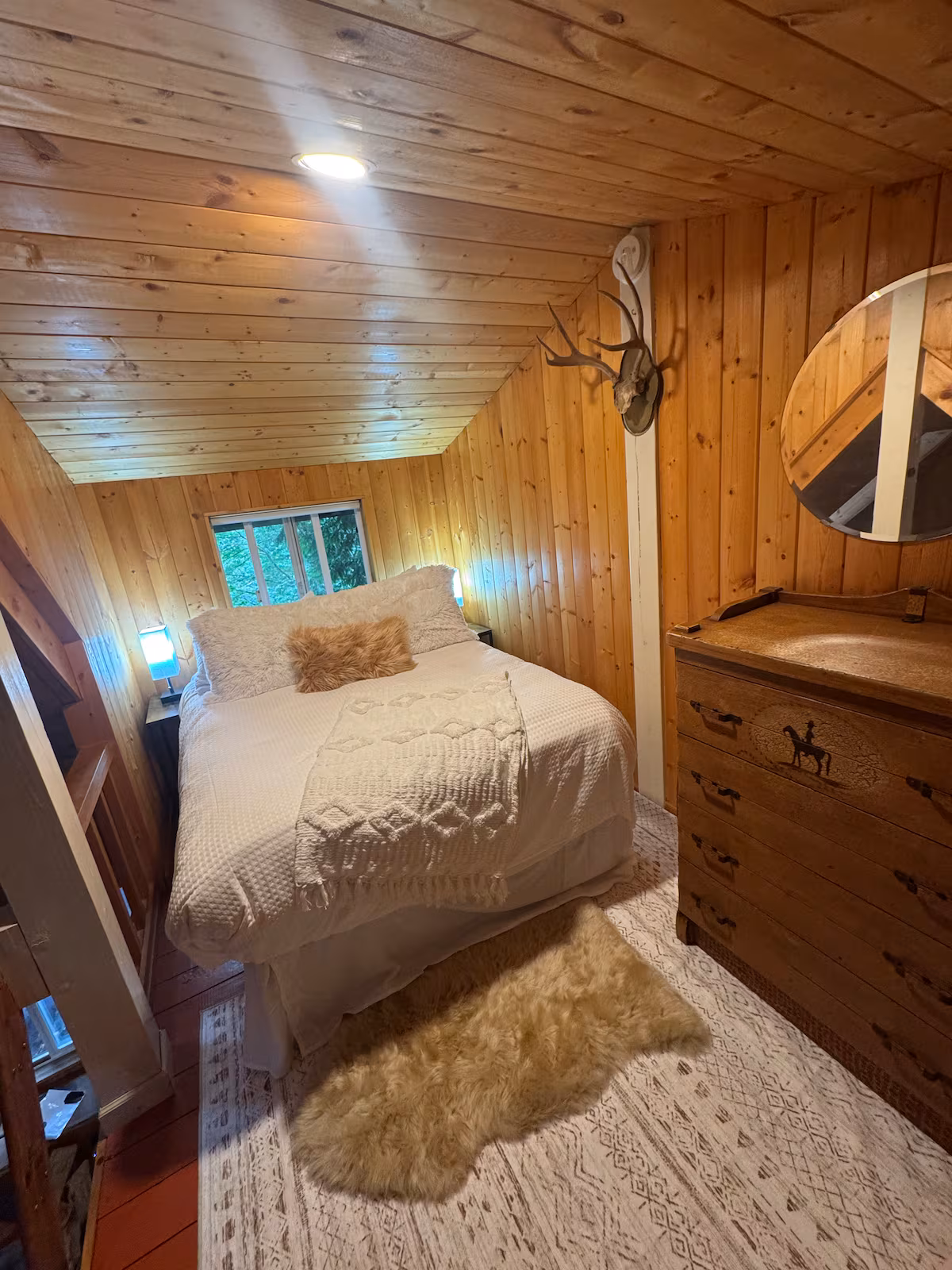 Cozy wooden bedroom with a bed and dresser.