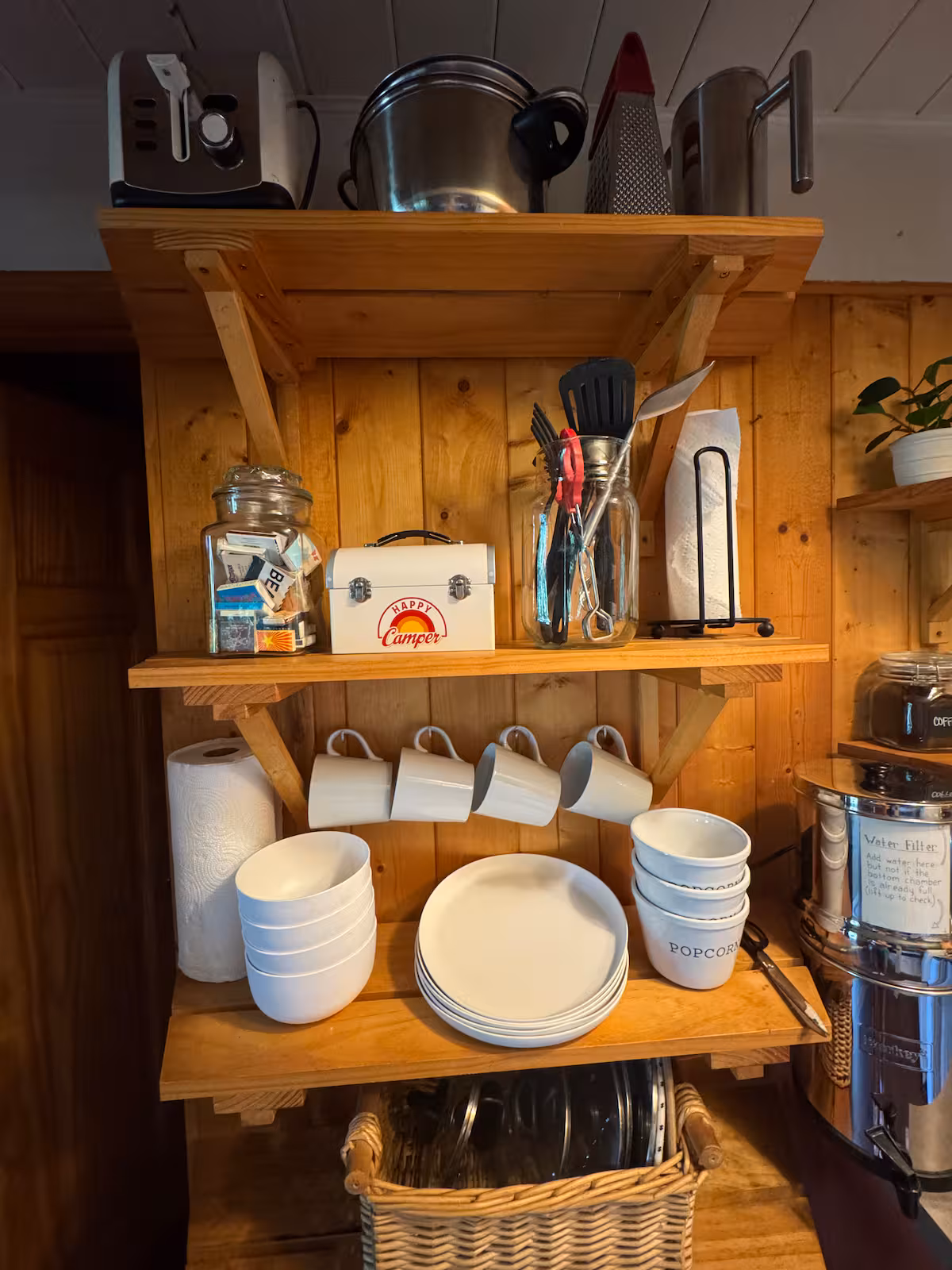 Wooden shelves with cups, plates, and kitchen items neatly arranged.