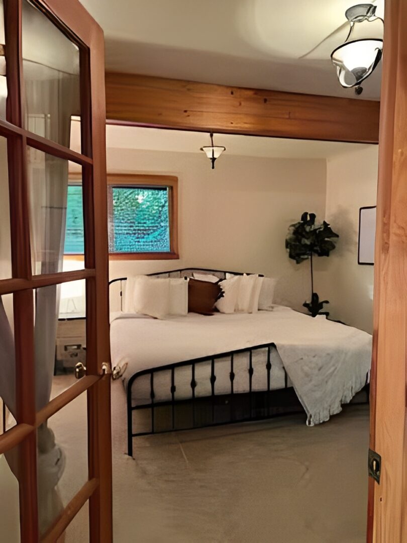 Cozy bedroom with rustic wooden beams and a wrought iron bed.