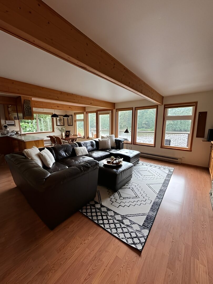 Cozy living room with large windows and sectional sofa.